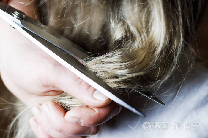大剪刀剪头发的金发女孩特写镜头调色
