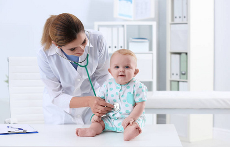 s doctor examining baby with stethoscope in hospital. Space for 