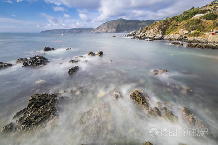 大海在岩石上移动，形成了一个美妙的海景，悬崖面对太平洋，走向无限，试图抓住地平线和云层，这是一个令人惊叹的景观