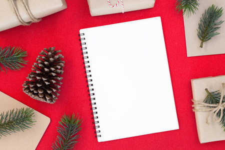 圣诞节和新年快乐组合礼品盒，松果，杉树枝，红色背景和复制空间白纸为您的文本。
