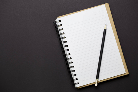 白纸和铅笔的顶部视图在黑色背景上,空空间用于文本信息照片