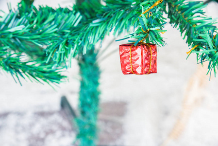 圣诞节装饰物品挂在树上圣诞快乐，新年快乐，圣诞树和金球球在抽象背景上的树枝上特写。