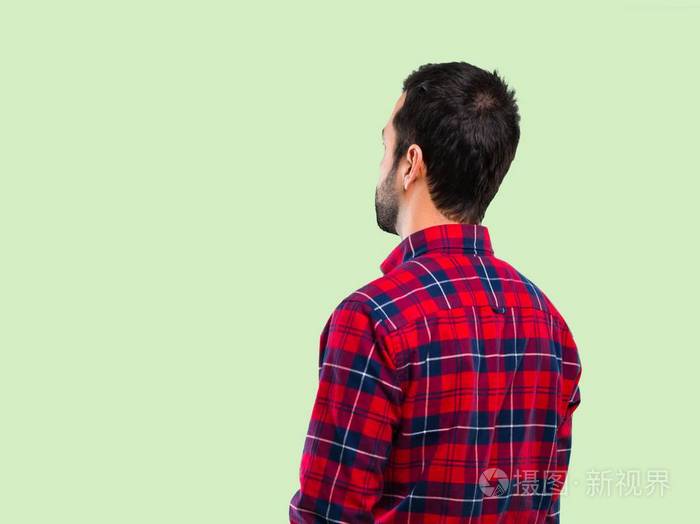 英俊的男人回头看绿色的背景照片-正版商用图片1601wu-摄图新视界