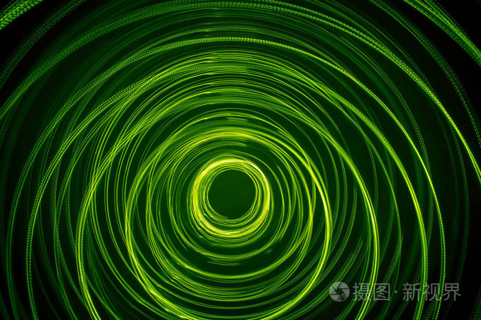 一个美丽,明亮的绿色漩涡.黑色背景下的未来派光绘画.圆形光圈