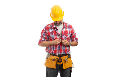 建筑工人低头看着扣扣子的格子衬衫，准备隔离在白色上的工作概念