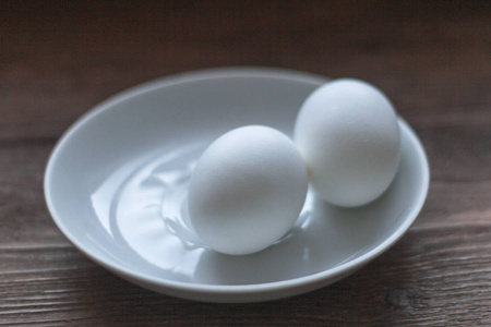 两个鸡蛋放在一个白色的碟子上
