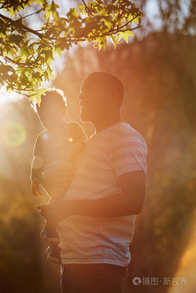 亲爱的爸爸抱着他的儿子,在公园里散步,亲密的亲密时刻