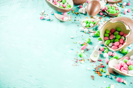 五颜六色的春天复活节糖果背景与巧克力鸡蛋，糖洒和棉花糖兔子绿松石，浅蓝色混凝土背景复制空间顶部视图