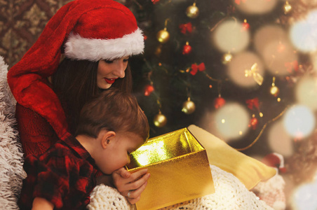 年轻美丽的母亲和她的小儿子正在寻找一个神奇的发光盒子与礼物。
