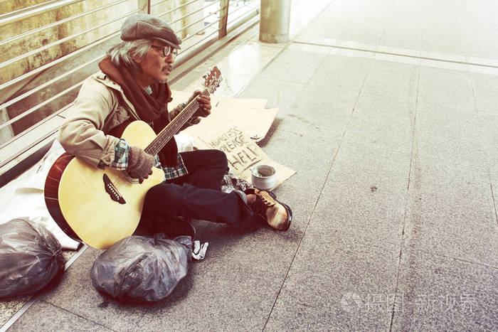 美丽的流浪汉在首都的步行街弹吉他