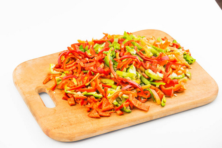 用甜椒切割纸板，把辣椒切成条。 五颜六色的甜椒混合着红黄绿。 顶部侧面白色