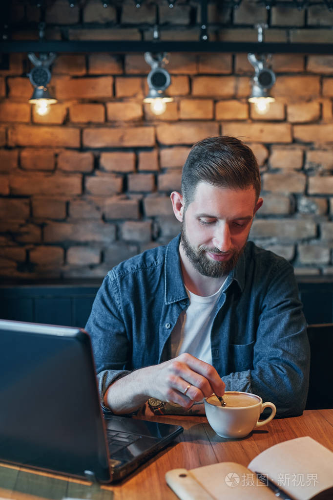 年轻人在城市咖啡馆喝咖啡在午餐时间和笔记本电脑工作
