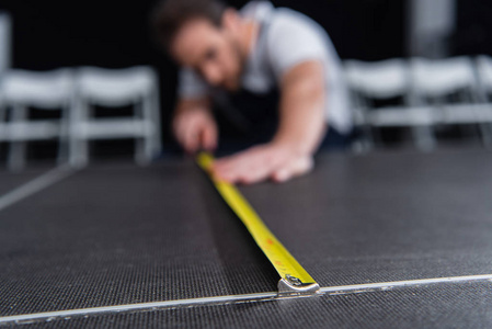 男匠用卷尺对地板进行测量的选择性聚焦