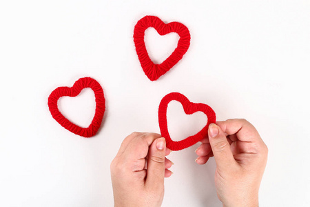 红色手工DIY心由纸板制成，纱线在白色背景上。情人节的礼物想法，一天的爱，2月14日的概念。一步一步。工艺流程。情人节贺卡