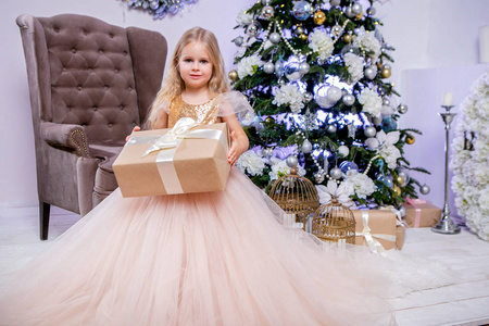 小公主穿着郁郁葱葱的白色礼服, 打开圣诞礼物。家庭外观。新年快乐和圣诞节主题。节日心情