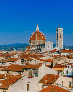 s Bell Tower under blue sky, over houses of the historical cente