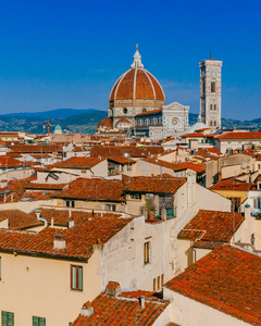 s Bell Tower under blue sky, over houses of the historical cente