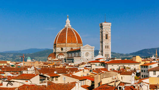 s Bell Tower under blue sky, over houses of the historical cente