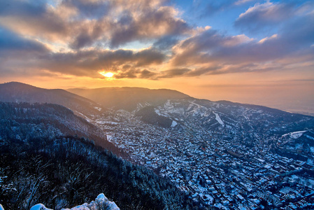 在冬季坦帕山上空日落时，布拉索夫市的全景
