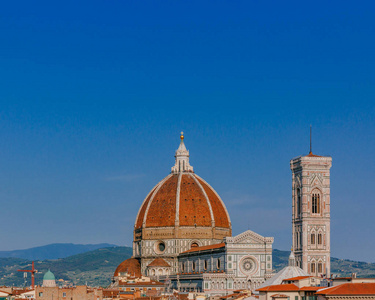 s Bell Tower under blue sky, over houses of the historical cente