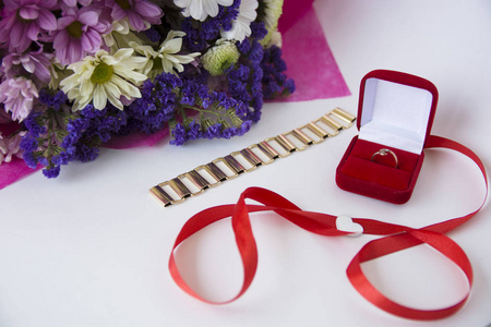 美丽的花束和带有金色结婚戒指的礼物盒