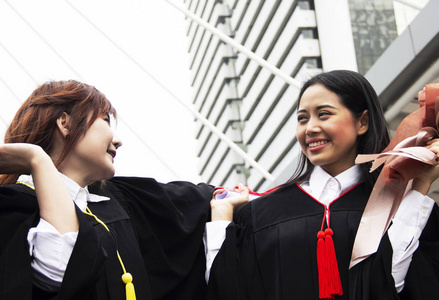 漂亮的两个女学生毕业后很高兴。