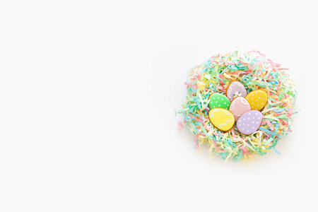 庆祝复活节的糖果。 姜饼形状的复活节兔子和复活节鸡蛋。 白色和彩色背景顶部视图复制空间