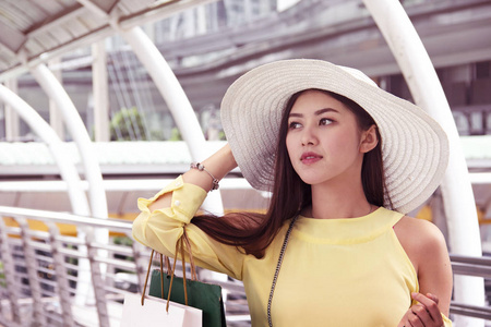 美丽的亚洲女人在城里快乐地散步购物。