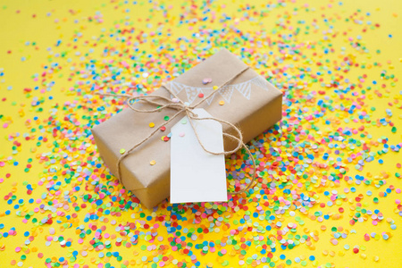 带黄麻绳的彩色礼品盒。 黄色背景。 派对或生日礼物。