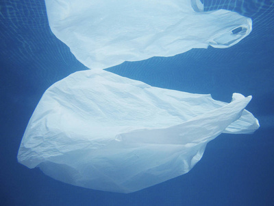 塑料袋漂浮在水中. 污染的环境. 回收垃圾照片