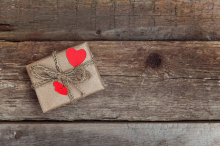 礼品盒，包裹工艺纸，红心在乡村时尚的老式木制背景。