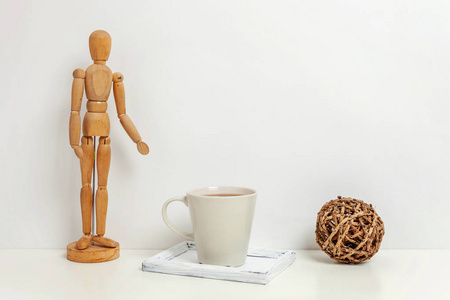 家或办公室装饰与人体模型咖啡杯附近的白色墙壁。极简主义室内工作场所艺术家用品装饰背景。海格斯堪的纳维亚风格的工作空间概念。复制空