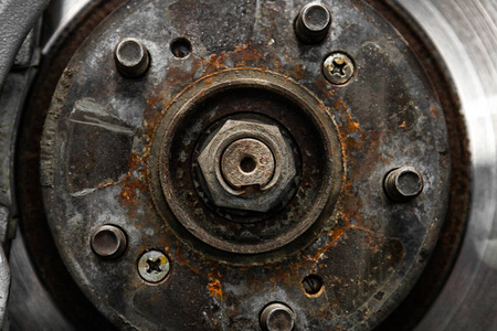 关闭旧的前制动盘制动卡尺和轮毂螺母的更换，在一个汽车修理车间的气动扳手的帮助下，在电梯上提起。 汽车修理工。