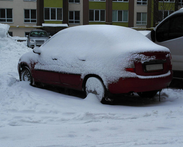 坏天气白色汽车覆盖着雪，背景是新家