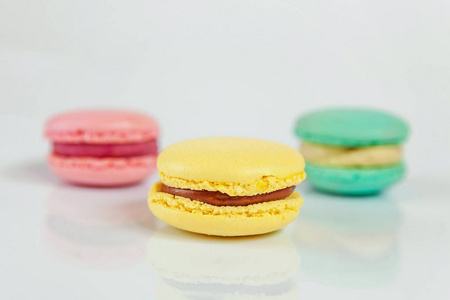 甜杏仁，彩色，粉红色，蓝色，黄色，通心粉或马卡龙甜点蛋糕分离在白色背景上。 法式甜饼。 最低食品烘焙概念。 复制空间