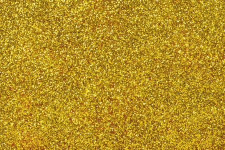 金色闪闪发光的背景从小亮片特写。 来自纺织品的明亮闪亮的背景。 闪烁的黄纸