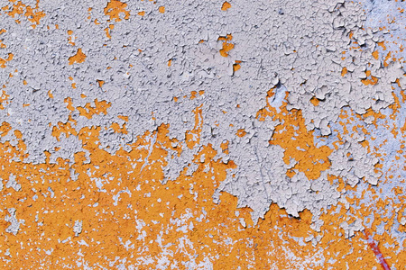 旧的粗糙混凝土表面上浅彩色橙色剥落油漆