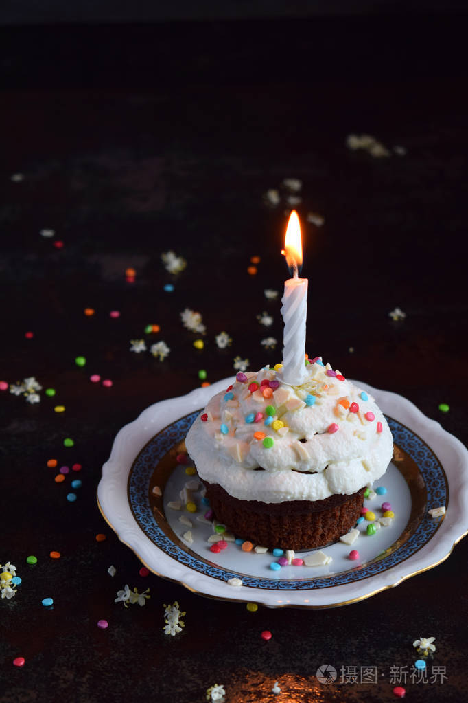 巧克力纸杯蛋糕香草奶油和蜡烛生日快乐深色照片