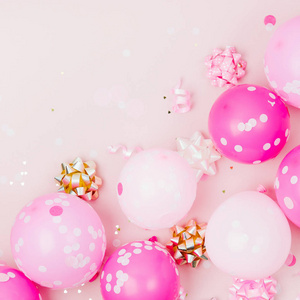 粉红色气球，有纸屑弓和纸饰。 生日派对概念主题。 平躺式顶部视图
