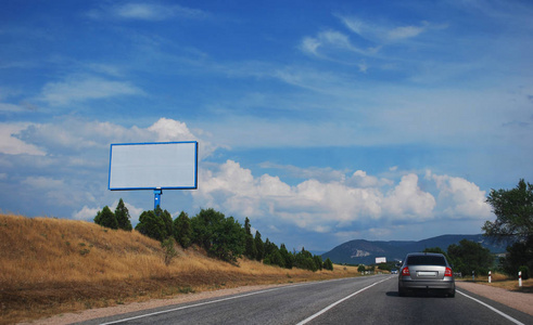 路上的广告牌，映衬着蓝天和云彩