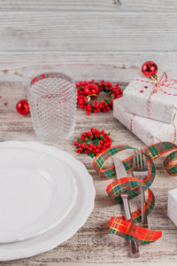 冬天的地方设置圣诞节和新年装饰在白色的木制桌子上。 圣诞晚餐的节日餐桌设置。