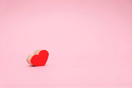 情人节背景与红色木头心脏在粉红色背景。2月14日贺卡