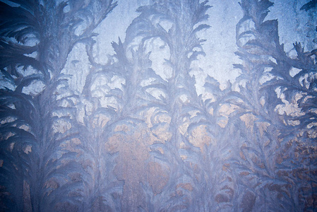 玻璃上的霜状图案。 冬季圣诞节抽象背景。 磨砂玻璃冰背景自然美丽的雪花。