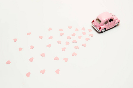 粉红色复古玩具车提供粉红色背景的花束花盒。2月14日情人节卡片。送花。3月8日, 国际妇女节快乐