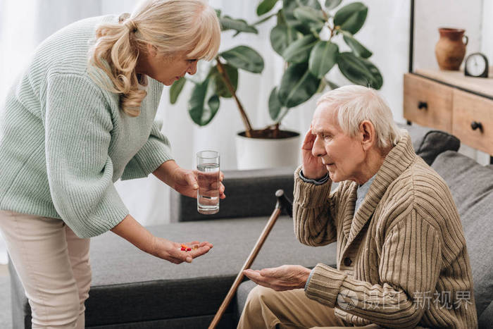 老人用手杖给老人吃药