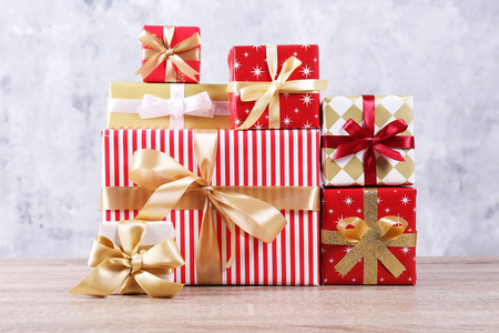 圣诞准备概念。 为每个家庭成员准备了一堆不同的五颜六色的礼物。 一堆礼物在明亮的节日包装。 关闭复制空间网格混凝土墙背景。