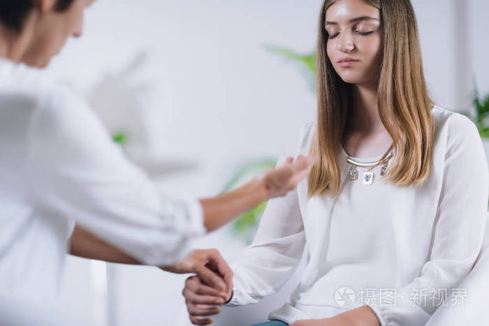 女性泰塔治疗治疗师与年轻女性患者进行替代治疗.