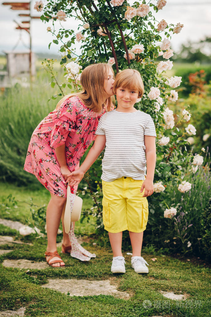 在阳光明媚的日子里两个时髦的孩子在花园里摆姿势的夏天肖像