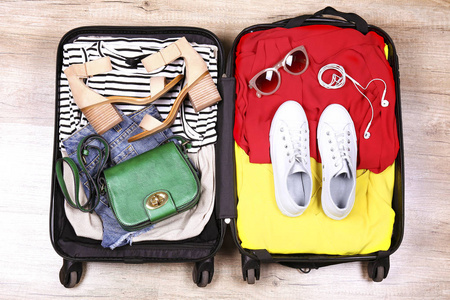 s clothing and accessories on the floor. Woman packing for tropi