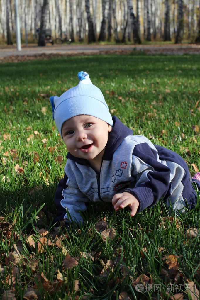 夏天在绿草如茵的公园里小宝宝抱着木头微笑